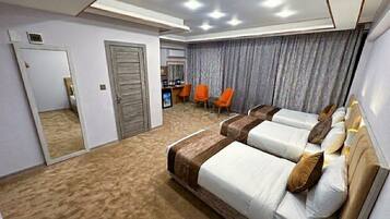 Habitación de hotel con una cama grande, un escritorio y una zona de estar con sillas.