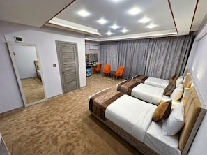 A hotel room with a large bed, a desk, and a seating area with chairs. - Qorqud Hotel - Free Breakfast & Dinner Included (Baku)