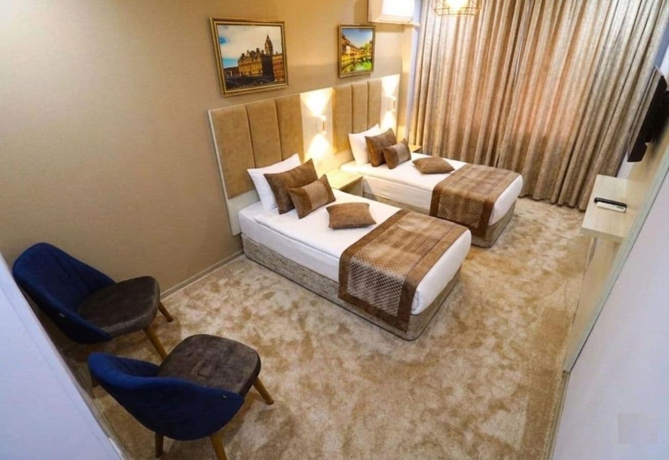 Una habitación de hotel con dos camas, un sofá y dos sillones.