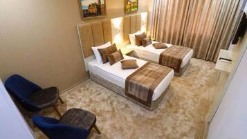 Una habitación de hotel con dos camas, un sofá y dos sillones.