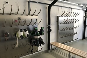 A wall with multiple hooks for hanging items, a bench, and a pipe running along the wall. - Alpine Chalet Hohe Tauern (Matrei i. Osttirol)