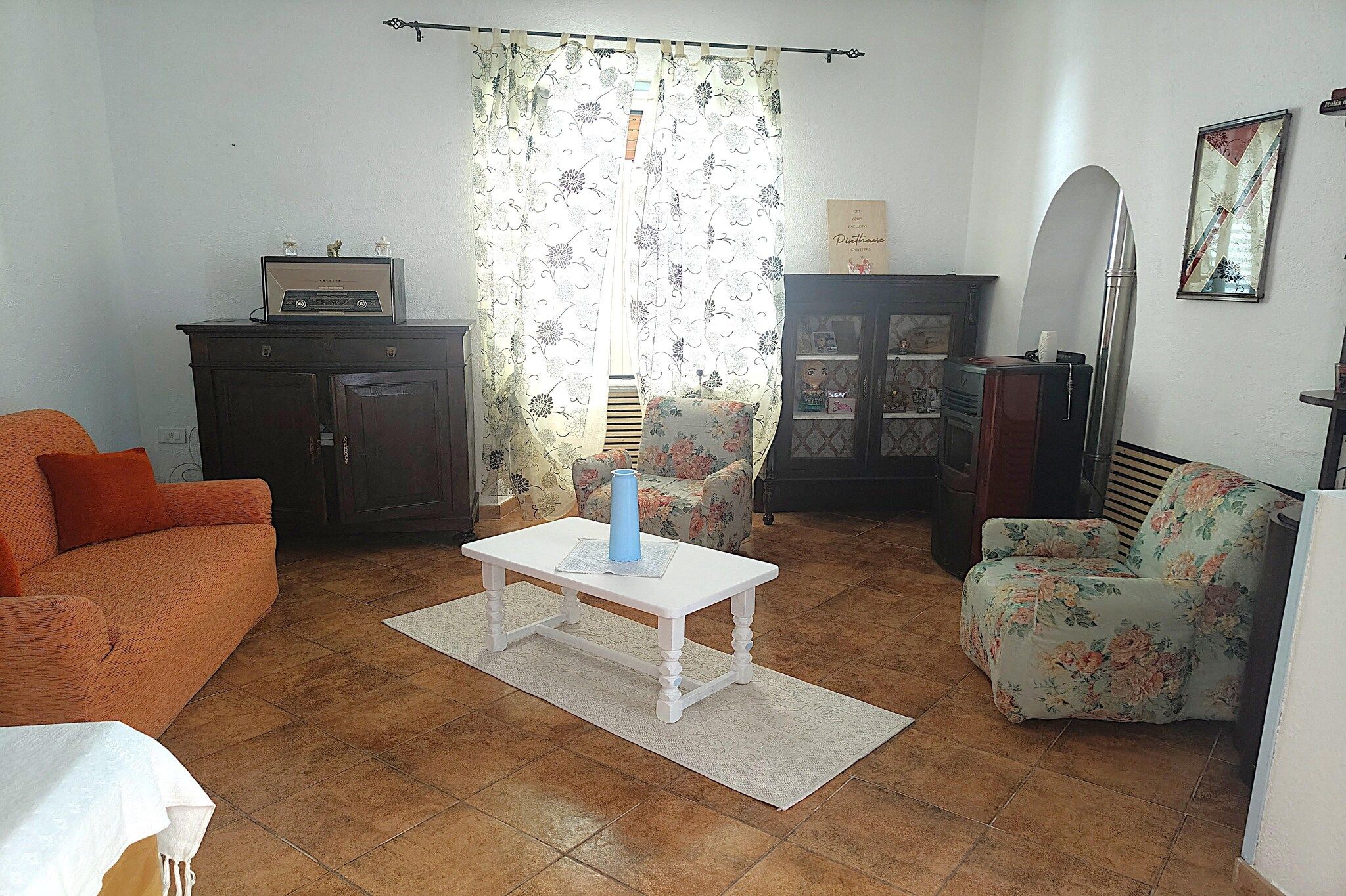 Un salon comprenant un canapé, une table basse, un meuble et un réfrigérateur.
