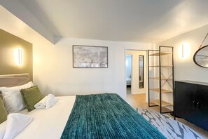 Ein Hotelzimmer mit Bett, Kleiderschrank, Spiegel und einem Bild an der Wand.
