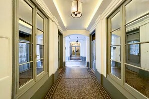 A long hallway with multiple doors on either side, leading to a staircase at the end. - Opera apartment in the heart of Paris (Paris)