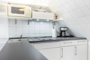 Eine moderne Küche mit Mikrowelle, Kaffeemaschine und Spüle.