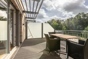 A balcony with a table and chairs, a pergola, and a view of trees. - Holiday home with 1 bedroom (St. Peter-Bad)