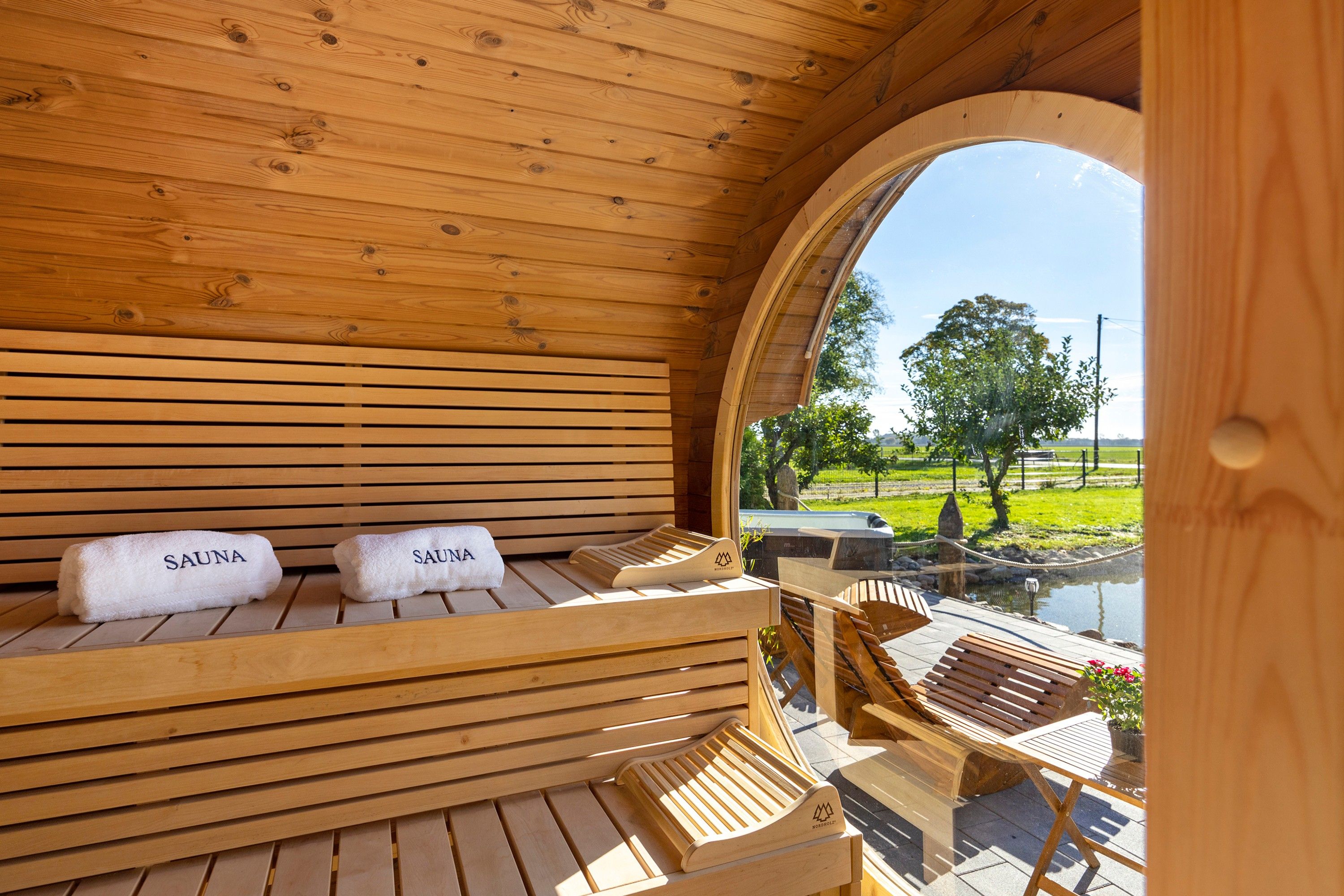 Een sauna met houten banken en twee handdoeken met de tekst 'SAUNA'.