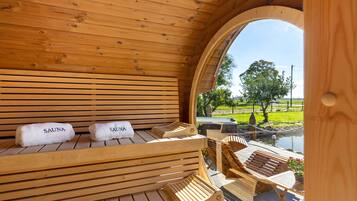 Een sauna met houten banken en twee handdoeken met de tekst 'SAUNA'.