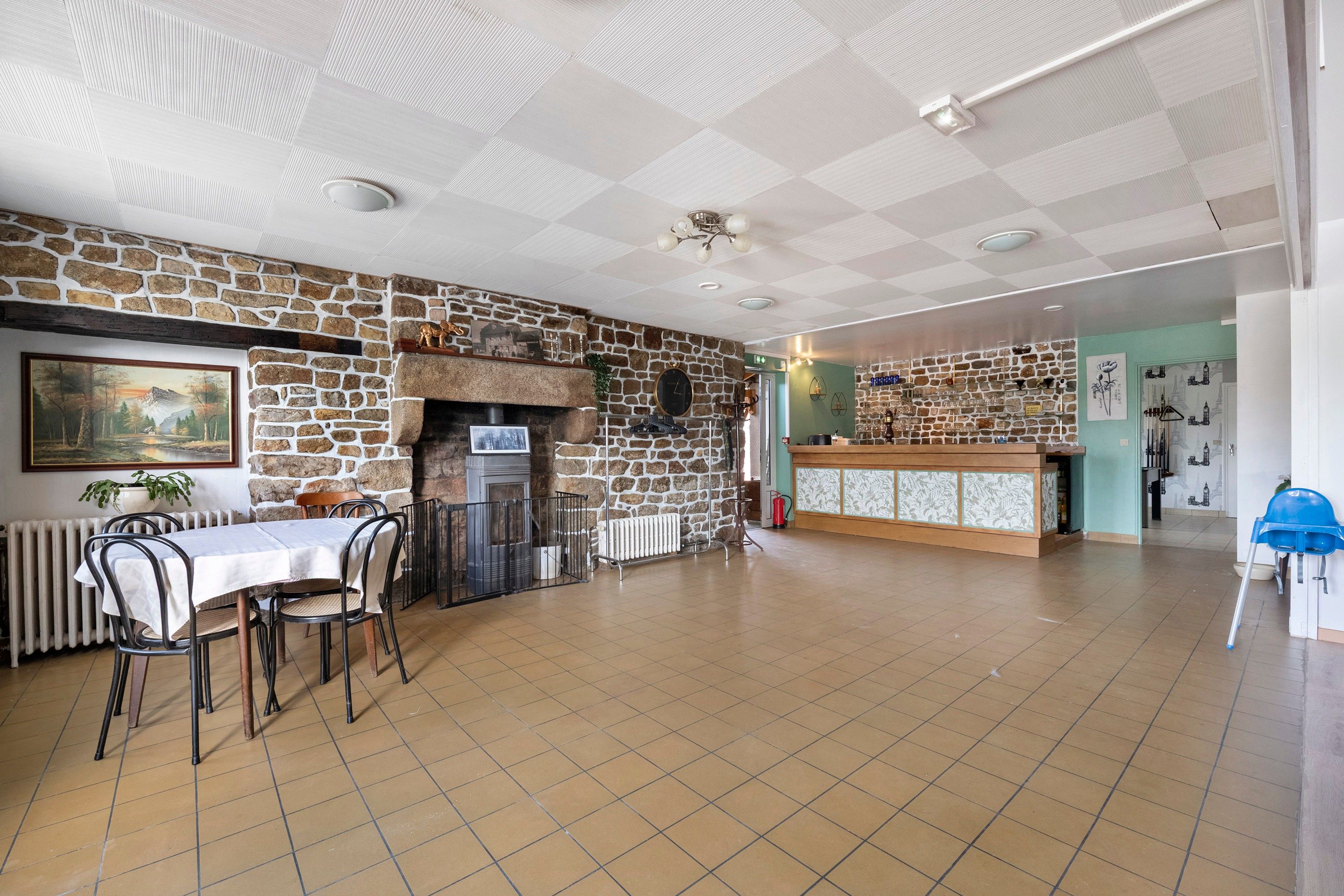 Ein Essbereich mit Steinwand, Kamin und Tisch mit Stühlen.