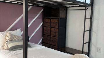 A bunk bed with a lower level bed and a top bunk with a metal railing.