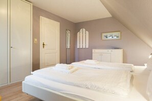 Ein Schlafzimmer mit Bett, Kleiderschrank und Tür.