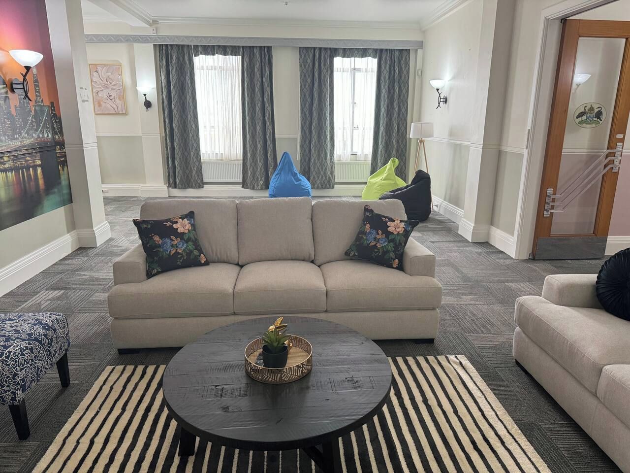 Un salon avec un canapé, une table basse et un tapis à motifs.