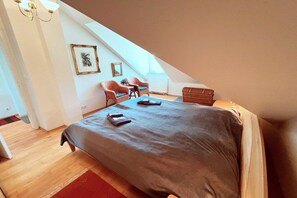 A bedroom with a bed, a chest of drawers, a chair, and a small table. - Holiday apartments with Baltic Sea view (Bansin (Seebad))
