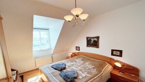 Una camera da letto con un letto, un comodino, una lampada, un portafoto e una finestra.