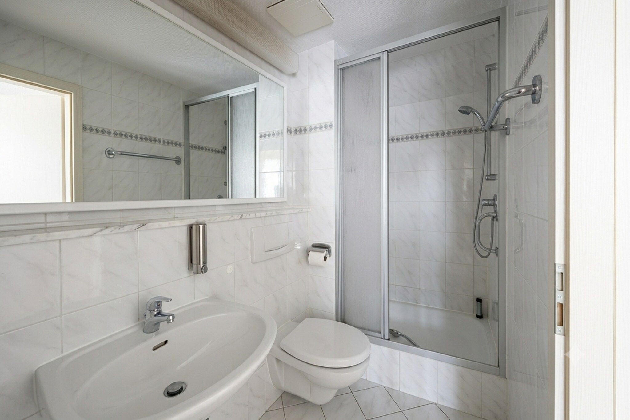 Ein modernes Badezimmer mit Badewanne, Toilette und einer Duschkabine.