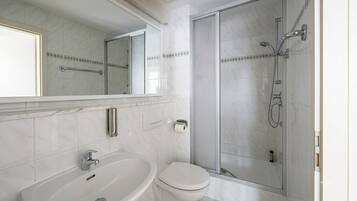 Ein modernes Badezimmer mit Badewanne, Toilette und einer Duschkabine.