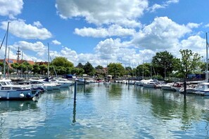 A marina with multiple boats docked, calm water, and a clear sky. - Holiday apartment with 1 bedroom (Langenargen)