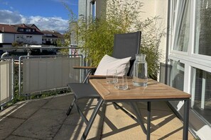 An outdoor seating area with a table, chairs, and a glass pitcher. - Holiday apartment with 1 bedroom (Langenargen)