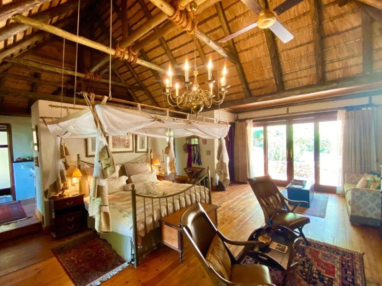Una habitación con cama, una silla, una mesa y un ventilador de techo.