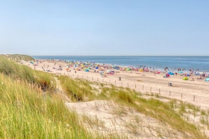A beach with a sandy shore and a fence. - Holiday home with 1 bedroom (Oude-Tonge)