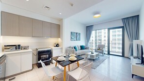 A modern apartment with a kitchen, dining area, and living room. - Homey 2 Bed l Dubai Hills Mall within Community (Dubai Hills)
