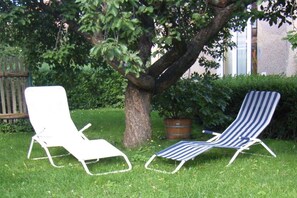 Two lounge chairs in a grassy area with a tree and a potted plant nearby. - Alice's Holiday Apartment 1 (Arnstadt)