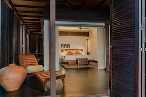 Una habitación con una cama, una silla de madera y una pequeña mesa.