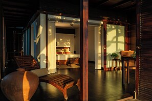 A room with a bed, a wooden chair, a table, and a potted plant. - Nanmah Beach Resort (Ambalapuzha)