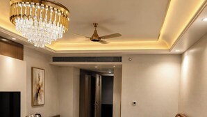 Une chambre d’hôtel moderne équipée d’un grand lit, d’une télévision, d’un bureau et d’un lustre.