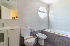 A modern bathroom with a toilet, bidet, sink, and bathtub. - Global Vacacional: Lovely studio with a corner balcony near the beach, Canet de Berenguer (Canet d´en berenguer)
