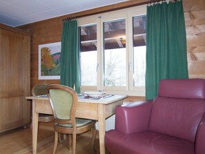 Ein Holzinnenraum mit einem Esstisch, einem Stuhl und einer Couch.
