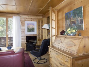 A cozy cabin interior with a wooden ceiling, a television, a leather sofa, a dining table, and a fireplace. - Cresta di Saas Appartement/Fewo 6-Bettwohnung by Interhome (Saas-Fee)
