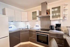 A modern kitchen with built-in appliances, a stove, oven, and a coffee maker. - Holiday apartment with 1 bedroom (Langenargen)