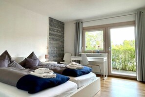 Een moderne hotelkamer met een groot bed, een bureau en uitzicht op groen.