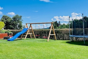 Ein Spielplatz mit Schaukel und Rutsche.
