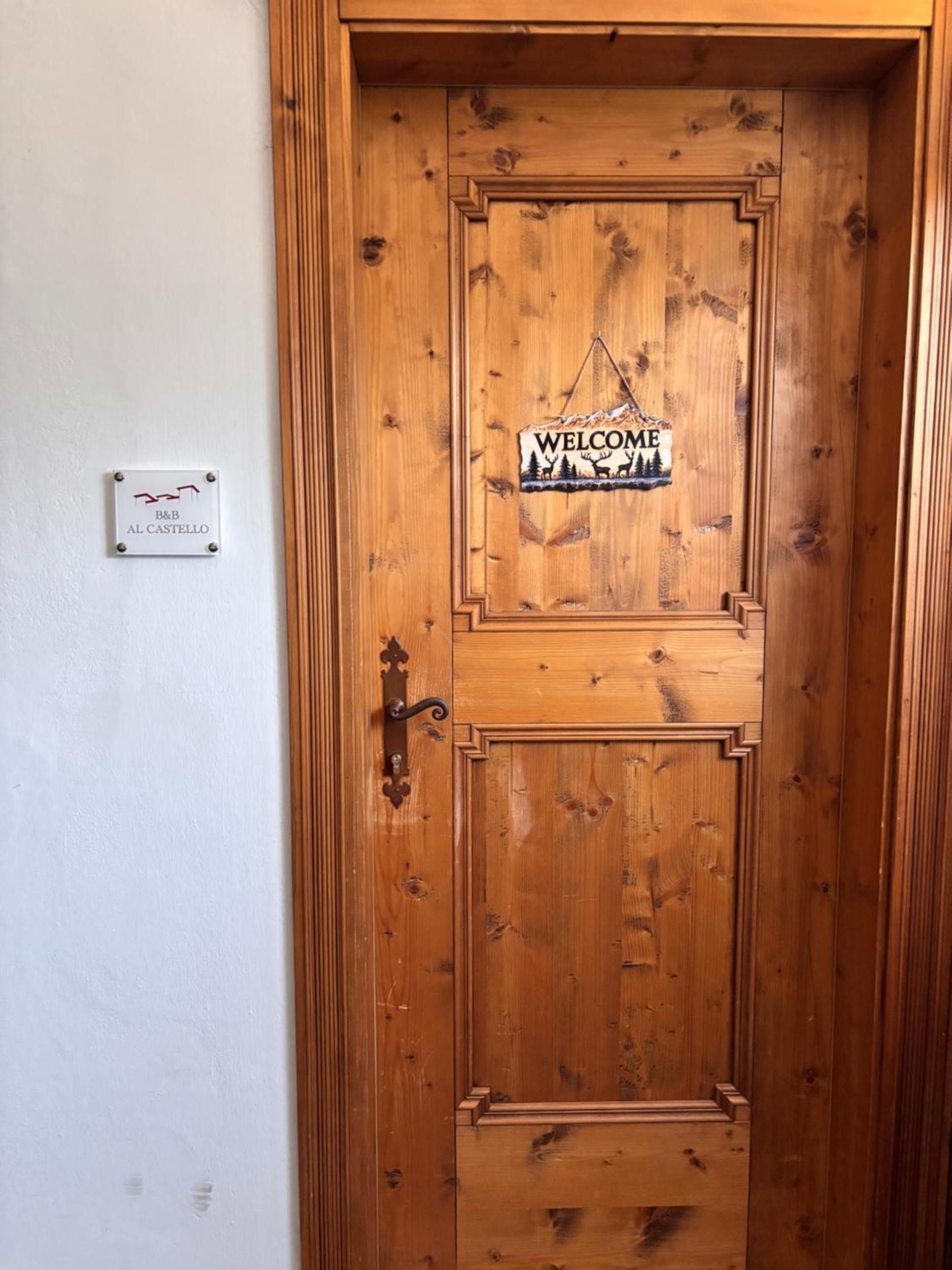 En trædør med en velkomstskilt og en skilt med hotellets navn.