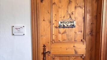 En trædør med en velkomstskilt og en skilt med hotellets navn.