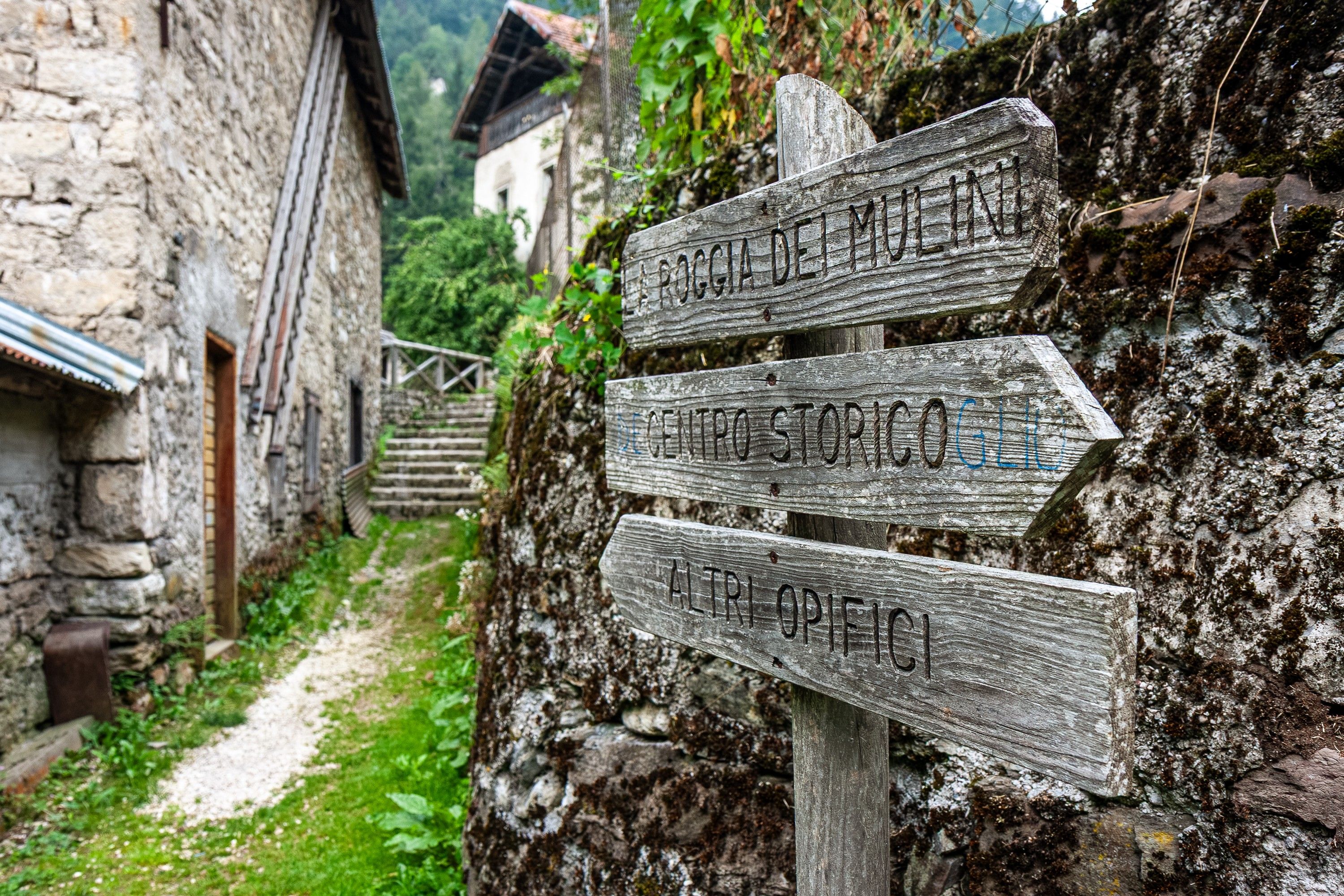 A rustic wooden signpost with directional arrows pointing to different destinations.