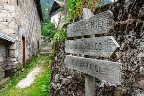 A rustic wooden signpost with directional arrows pointing to different destinations.