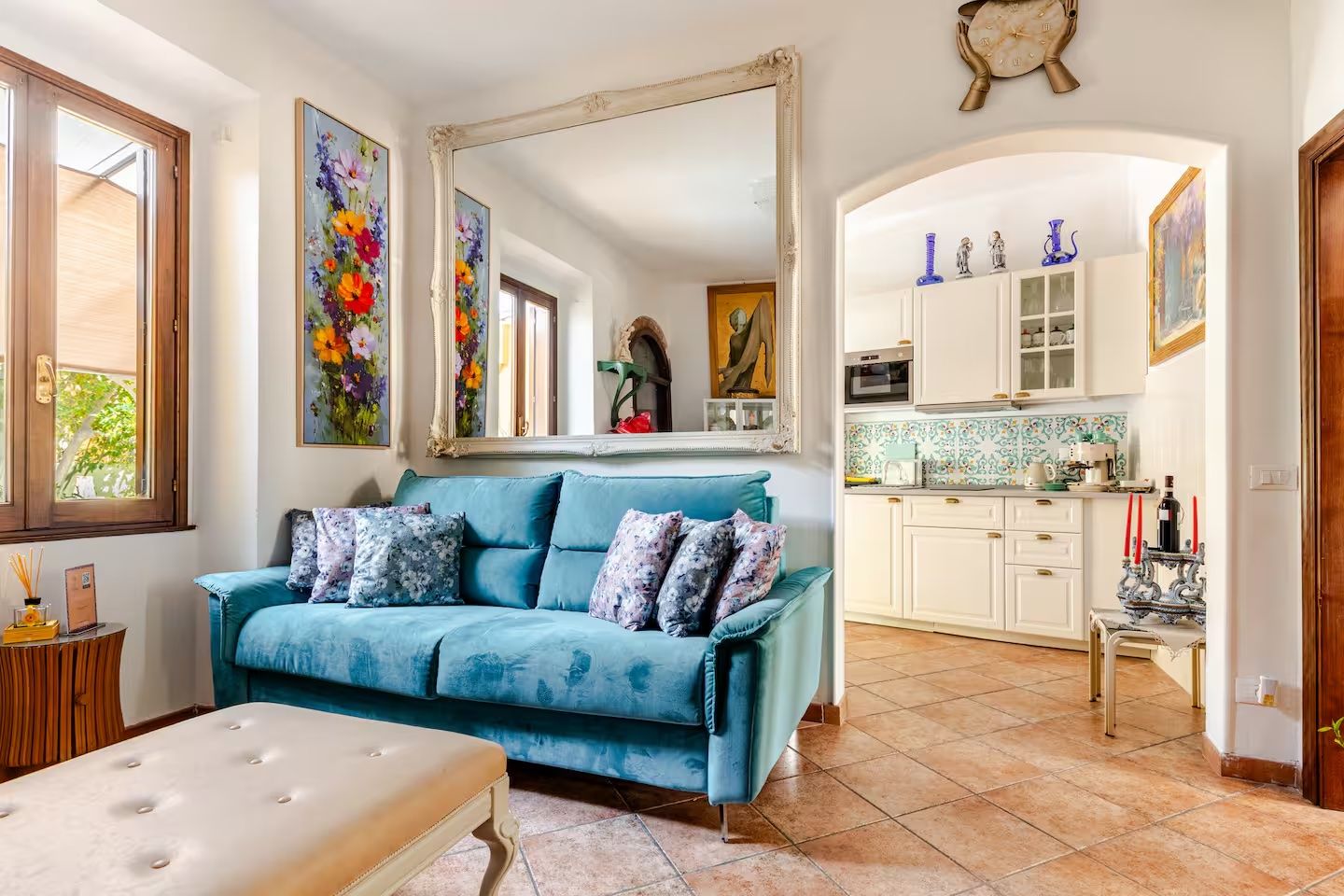 Una sala de estar con un sofá azul, una mesa de centro y un espejo grande.
