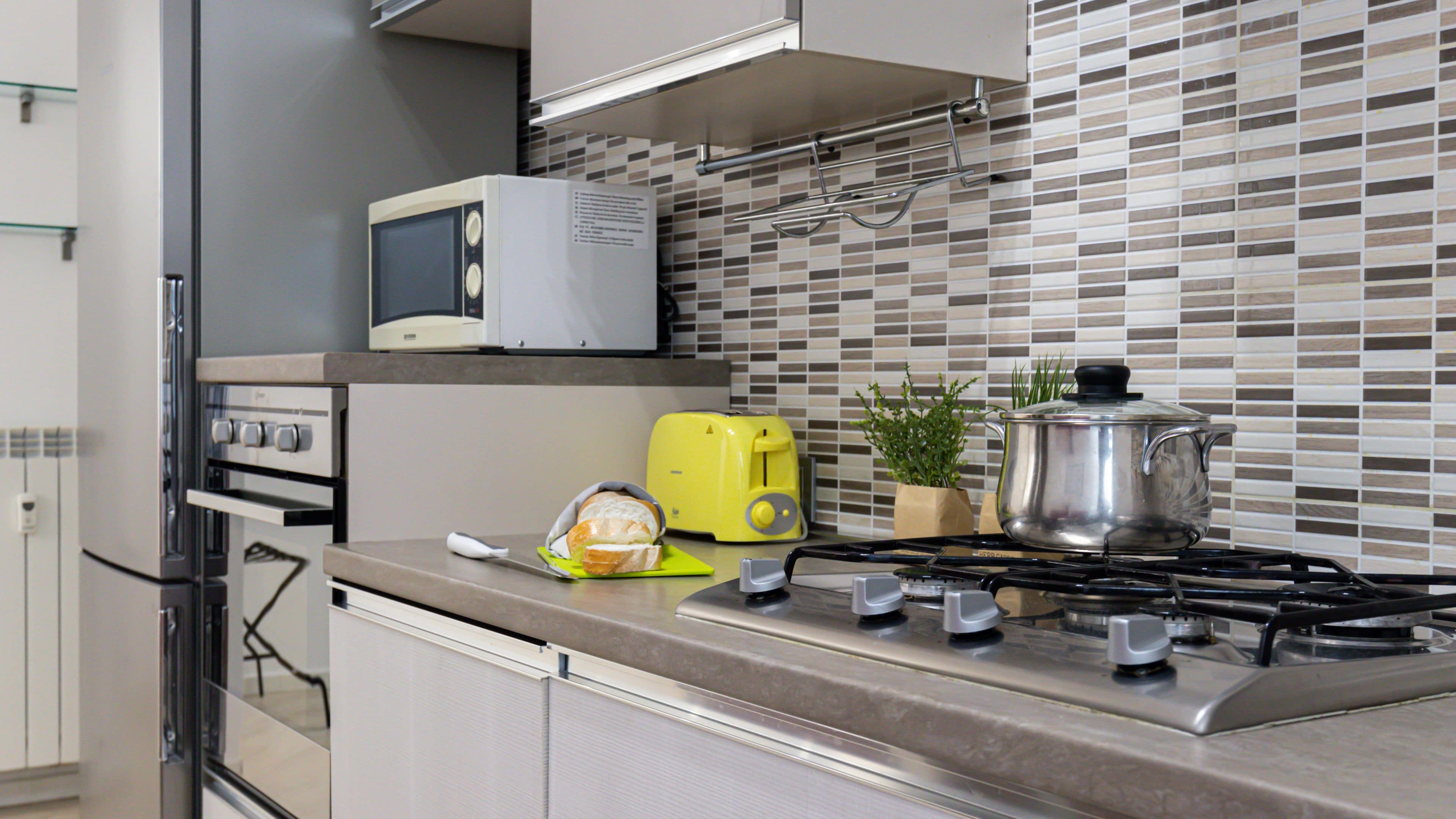 A modern kitchen with a microwave, toaster, and gas stove.