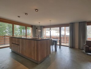 A modern kitchen with a central island, large windows, and a view of a snowy landscape. - Derby Appartement/Fewo 8-Bettwohnung by Interhome (Saas-Fee)