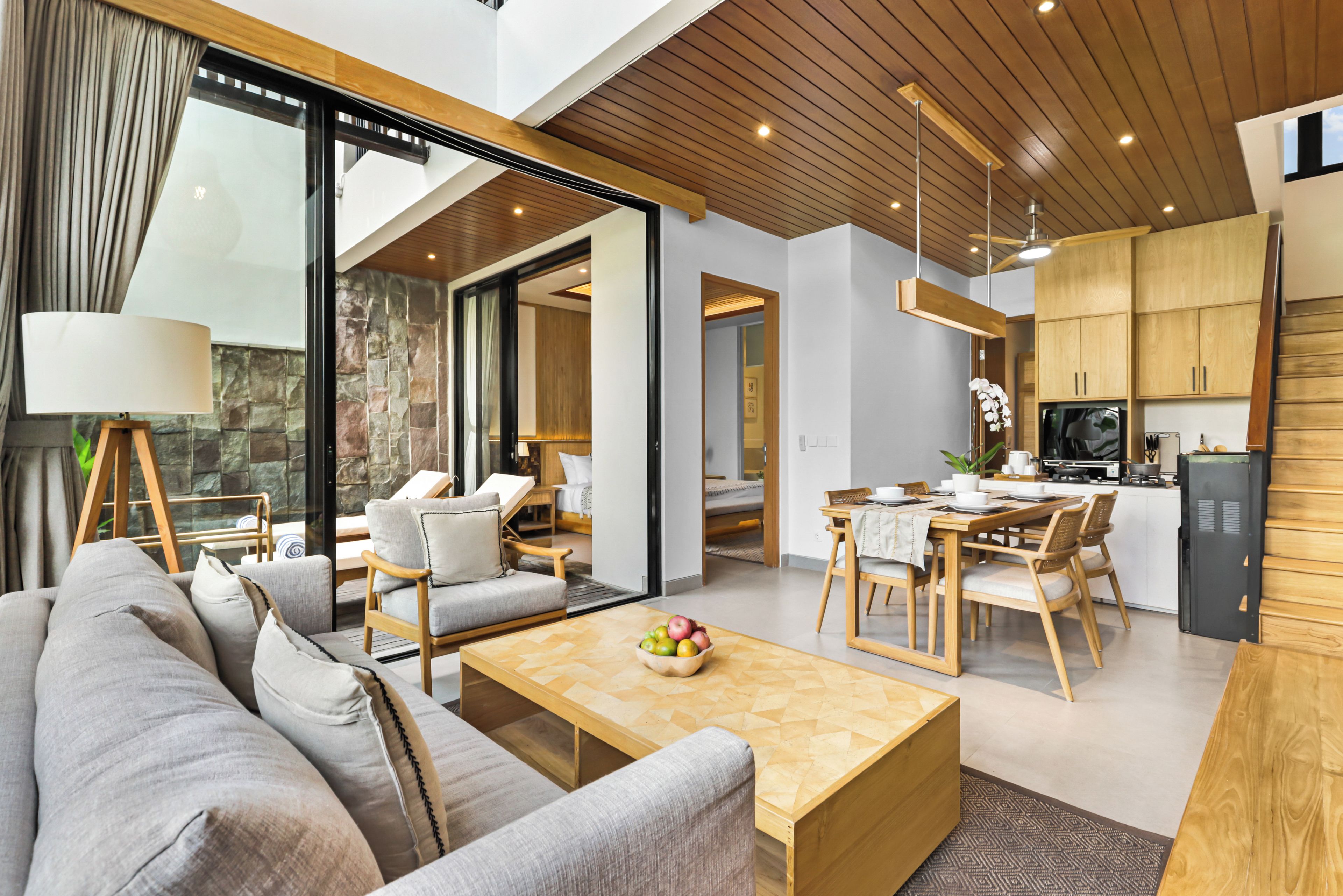 Een moderne woonkamer met een bank, salontafel en eethoek.