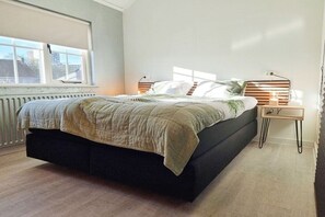 A bedroom with a bed, bedside tables, and a window. - VL19 Holiday home Zuidkust Vlissingen (Vlissingen)