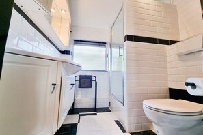 A modern bathroom with a toilet, a sink, and a window. - VL19 Holiday home Zuidkust Vlissingen (Vlissingen)
