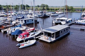 A marina with various boats docked, including sailboats and motorboats.