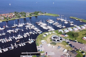 A marina with numerous boats docked, a central circular building, and surrounding residential buildings.