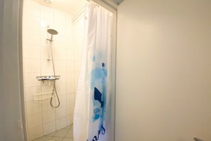 Ein Badezimmer mit Dusche, Handtuchhalter und einem blauen Vorhang.
