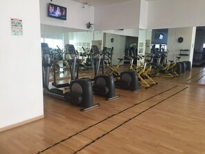 A gym with exercise equipment, mirrors, and a television screen. - Large Apartment, Hosts 2 -4 Adults/ Children.1-bedroom, 1 double Sofa bed. (Mexico)
