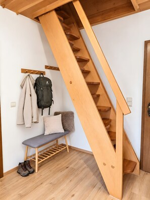 A wooden staircase with a bench and a coat rack. - Family Apartment No. 5 at Maierbauernhof Holiday Paradise (Bad Peterstal-Griesbach)